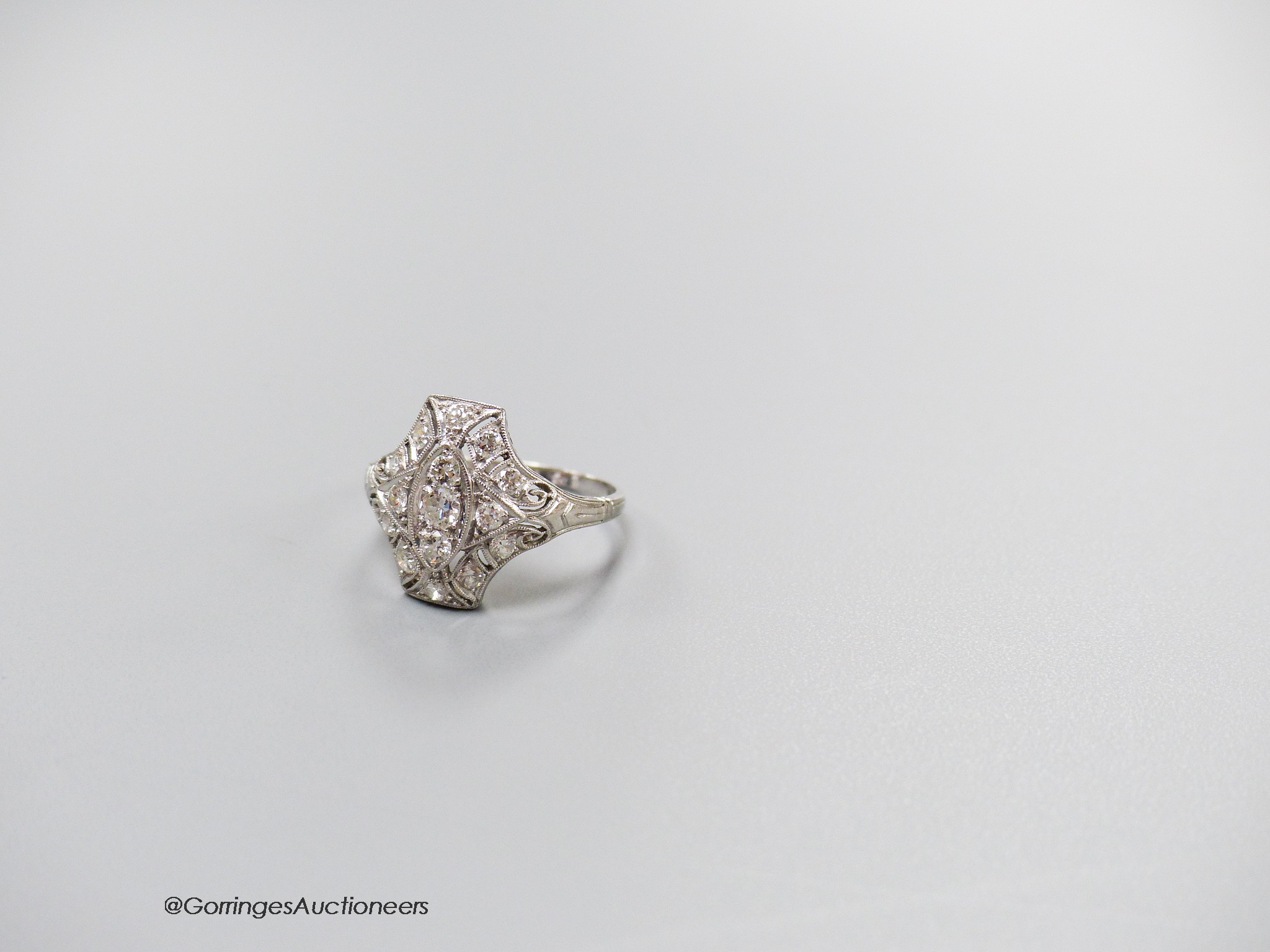 A 1920's pierced white metal and diamond cluster dress ring, size M, gross 3.5 grams.